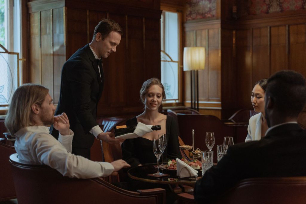 A waiter serving guests at a table in an elegant restaurant