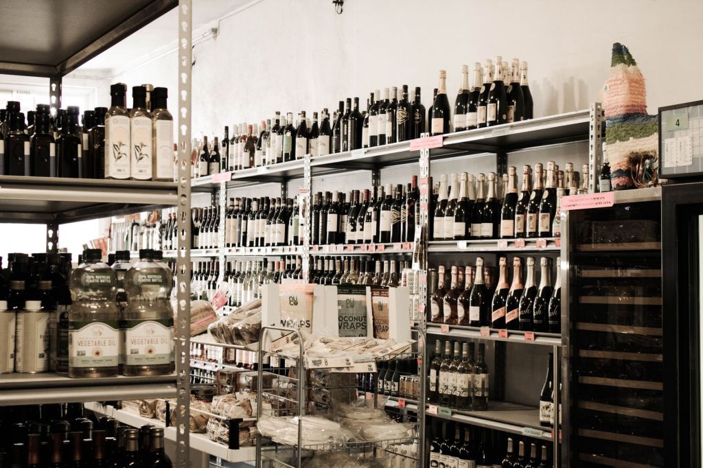 Bright wine shop with shelves lined with bottles from floor to ceiling